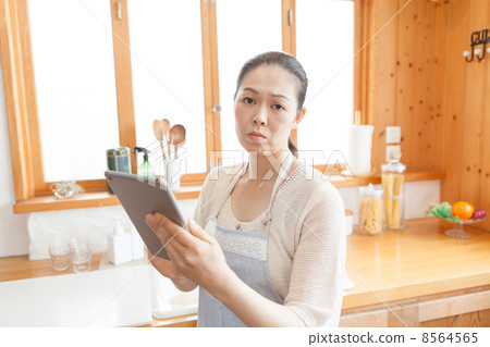 A housewife with a tablet in the kitchen 8564565