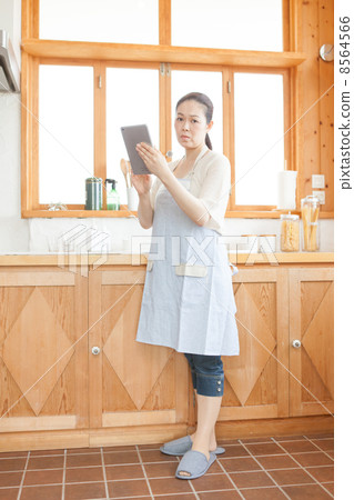 有一種片劑的一位主婦在廚房裡 有一種片劑的一位主婦在廚房裡 8564566