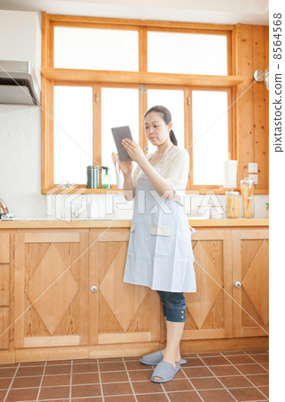 有一種片劑的一位主婦在廚房裡 有一種片劑的一位主婦在廚房裡 8564568