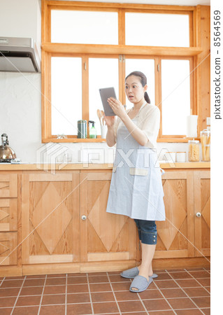 A housewife with a tablet in the kitchen 8564569