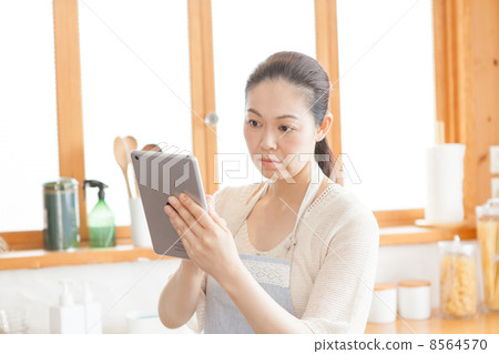 有一種片劑的一位主婦在廚房裡 有一種片劑的一位主婦在廚房裡 8564570