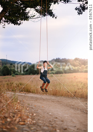 Happy young boy playing on swing in a park 8567611