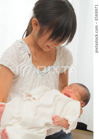 抱著嬰兒的小學學生 抱著嬰兒的小學學生 8569971