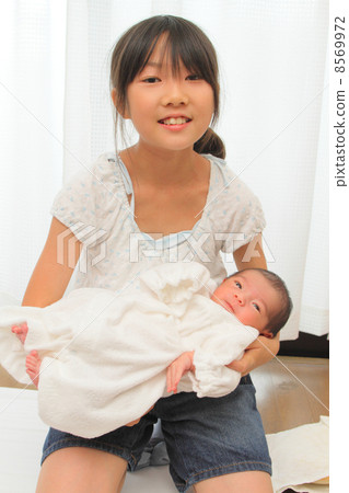 抱著嬰兒的小學學生 8569972