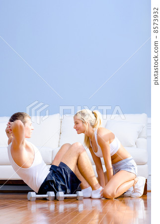 Couple Exercising on Living Room Floor Couple Exercising on Living Room Floor 8573932