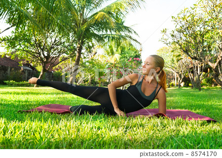 Woman doing yoga in garden 8574170