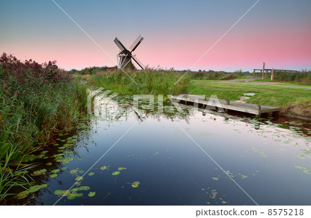 Dutch windmill by river at sunrise Dutch windmill by river at sunrise 8575218