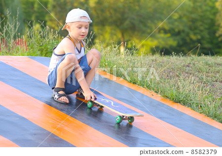 Boy Child Training Skateboard Outdoor Summer Sport with nature on background 8582379