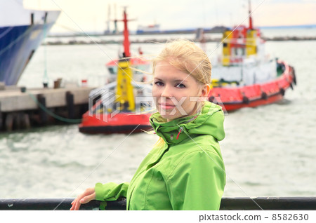 Young Woman Traveling on Ship and hold on handrails with boats and sea on background 8582630