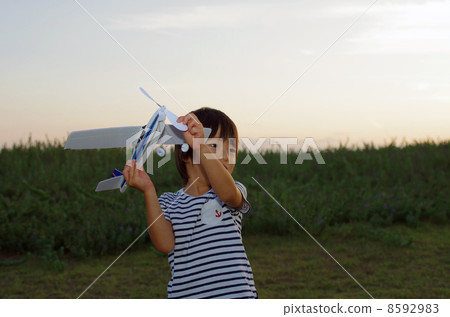 A sunset scenery and a child flying a model plane A sunset scenery and a child flying a model plane 8592983