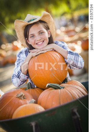 Preteen Girl Playing with a Wheelbarrow at the Pumpkin Patch. Preteen Girl Playing with a Wheelbarrow at the Pumpkin Patch. 8597594