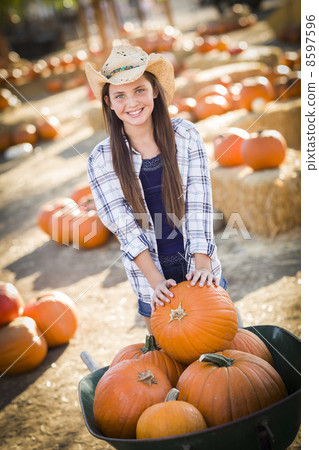 Preteen Girl Playing with a Wheelbarrow at the Pumpkin Patch. Preteen Girl Playing with a Wheelbarrow at the Pumpkin Patch. 8597596