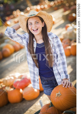 Preteen Girl Playing with a Wheelbarrow at the Pumpkin Patch. Preteen Girl Playing with a Wheelbarrow at the Pumpkin Patch. 8597600