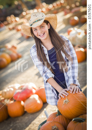 Preteen Girl Playing with a Wheelbarrow at the Pumpkin Patch. Preteen Girl Playing with a Wheelbarrow at the Pumpkin Patch. 8597601