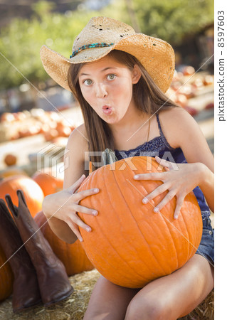 Preteen Girl Holding A Large Pumpkin at the Pumpkin Patch. Preteen Girl Holding A Large Pumpkin at the Pumpkin Patch. 8597603