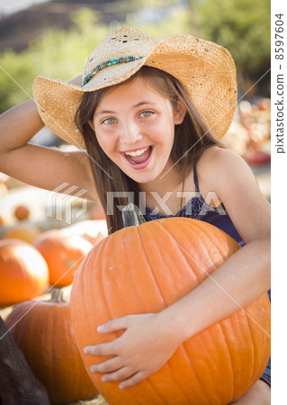 Preteen Girl Holding A Large Pumpkin at the Pumpkin Patch. Preteen Girl Holding A Large Pumpkin at the Pumpkin Patch. 8597604