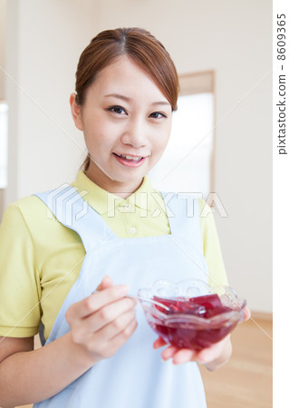 Young female caregiver meal assistance 8609365