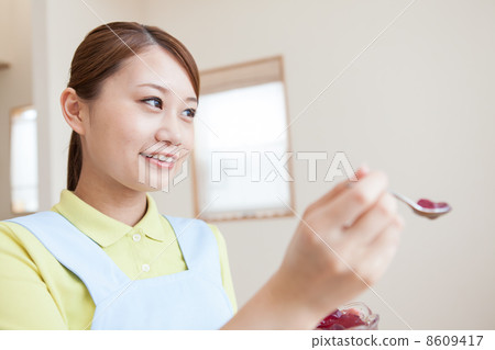 Young female caregiver meal assistance 8609417