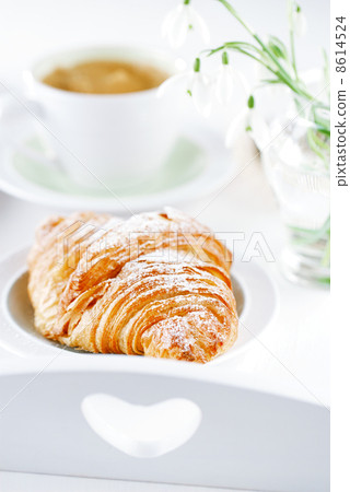 Croissant with coffee, on sunlit breakfast tray Croissant with coffee, on sunlit breakfast tray 8614524