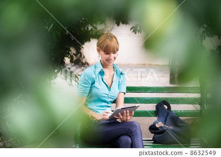 hispanic woman with digital tablet pc on bench 8632549