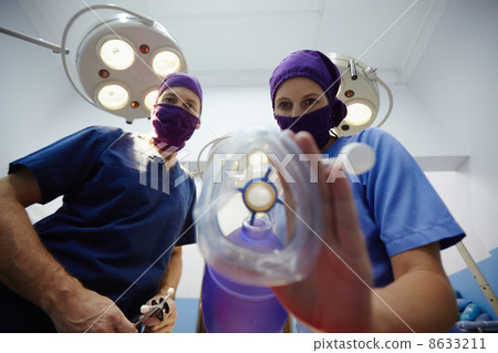 Operation room in clinic with medical staff during surgery 8633211