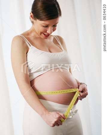 pregnant woman with measuring tape 8634410