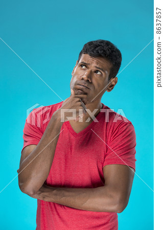 Excited Indian man looking up. Against blue background. 8637857