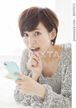 A woman watching a smartphone A woman watching a smartphone 8647813
