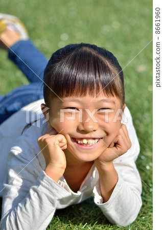 A girl with a cheeks stick at the lawn open space A girl with a cheeks stick at the lawn open space 8661960