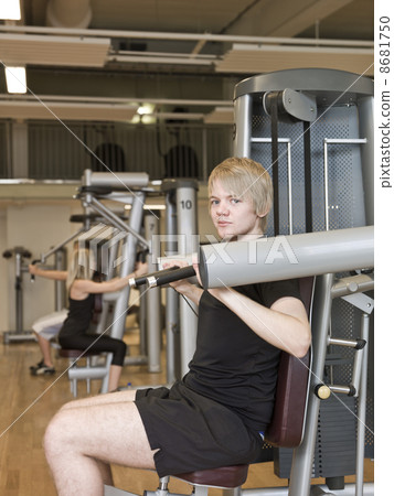 Young man using an exercise machine Young man using an exercise machine 8681750