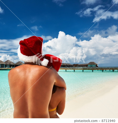 Couple in santa's hat on a beach at Maldives 8711940
