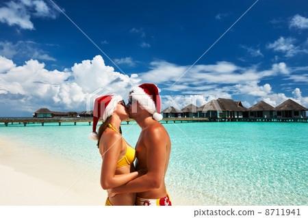 Couple in santa's hat on a beach at Maldives 8711941