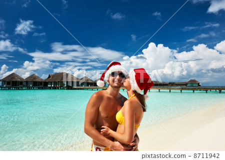 Couple in santa's hat on a beach at Maldives 8711942