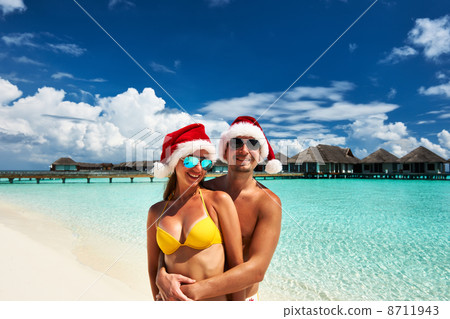 Couple in santa's hat on a beach at Maldives 8711943