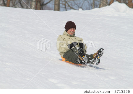 A man playing on a sled 8715336