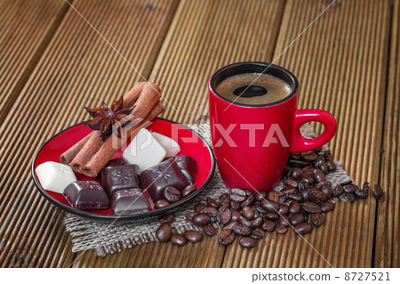Coffee in a red cup with cinnamon and anise stars. Coffee in a red cup with cinnamon and anise stars. 8727521