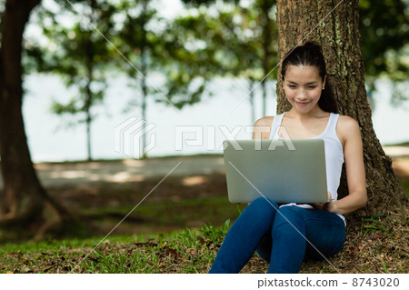 Woman on her Laptop in the park 8743020