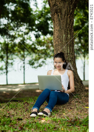 Woman on her Laptop in the park Woman on her Laptop in the park 8743021