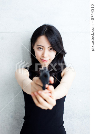 A woman holding a handgun 8744510