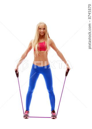 Cute aerobics instructor posing with skipping rope 8745870