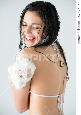 Young woman washing body with shower gel 8747326