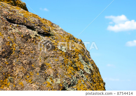 Lichen and moss on old granite rock against of blue sky. Lichen and moss on old granite rock against of blue sky. 8754414