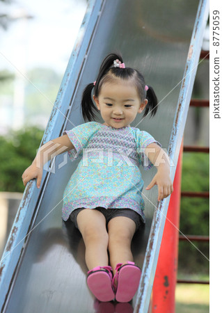 女孩在公園裡的幻燈片上玩 女孩在公園裡的幻燈片上玩 8775059