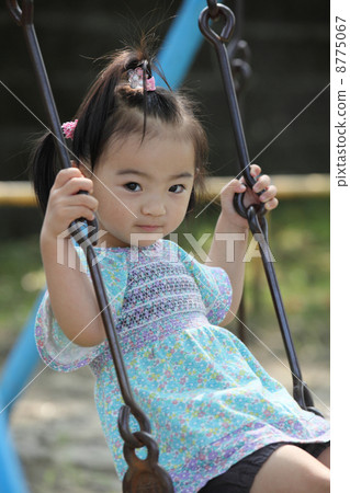 A girl playing with a swing in a park A girl playing with a swing in a park 8775067