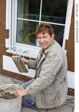 Young man tiling on balkony ceramic tiles 8776385
