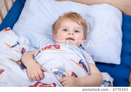 Little blond toddler boy in bed 8776393