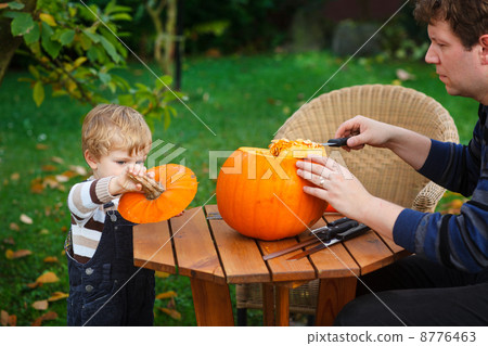 Young man and toddler boy making halloween pumpkin 8776463