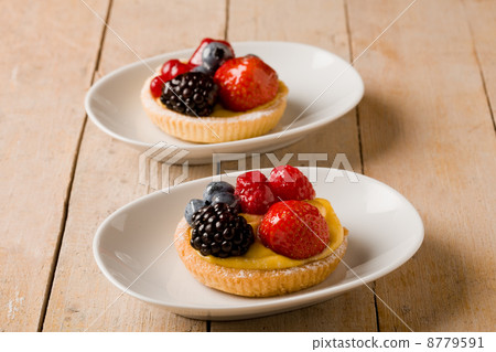 Pastry with berries on wooden table Pastry with berries on wooden table 8779591