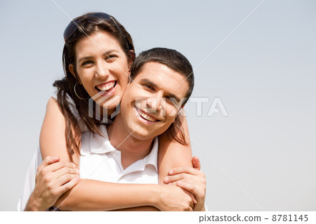 Happy young guy piggybacking his girlfriend Happy young guy piggybacking his girlfriend 8781145
