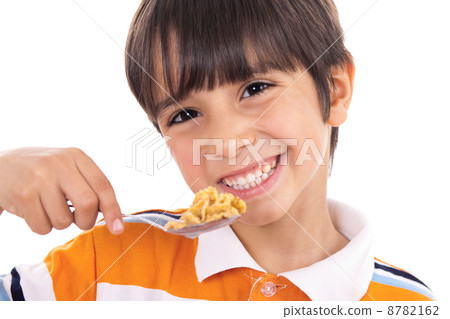 Smiling young boy with spoon of flakes, closeup 8782162